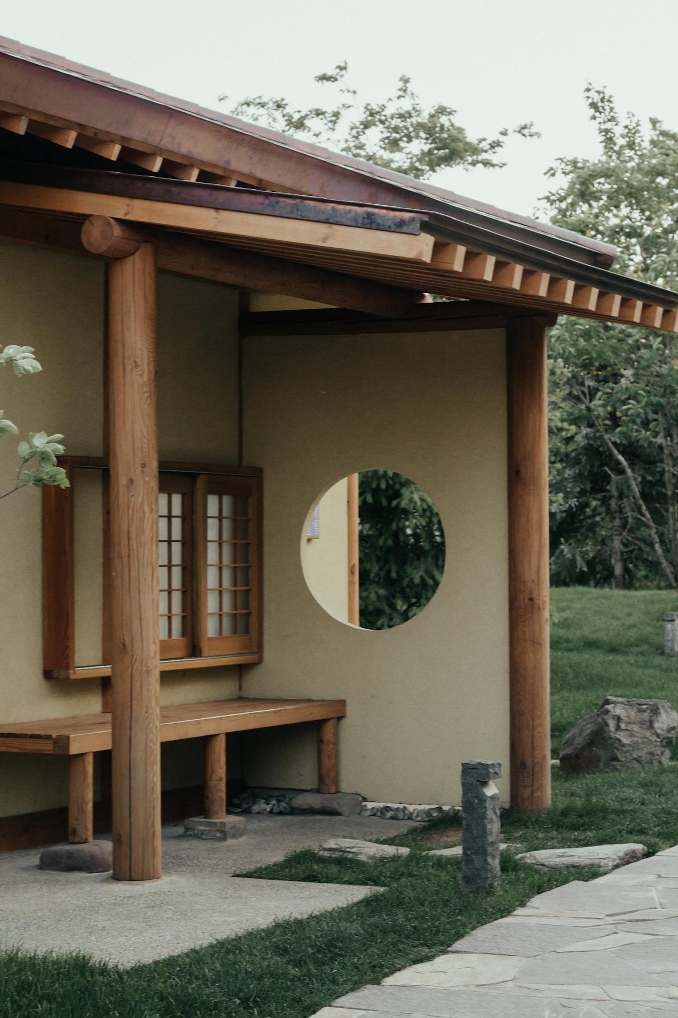Natural wooden beams and circular window detail on a rural building in Russia.